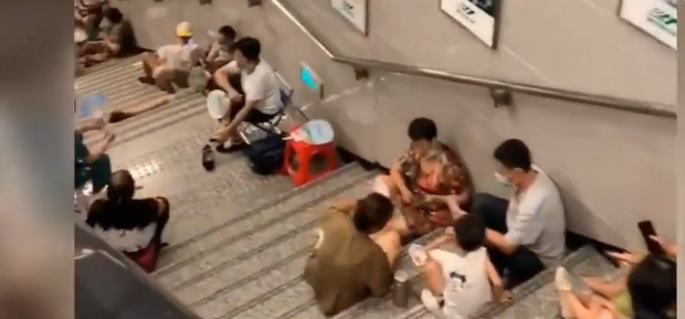 重庆高温炙热， 居民在地铁楼梯避暑